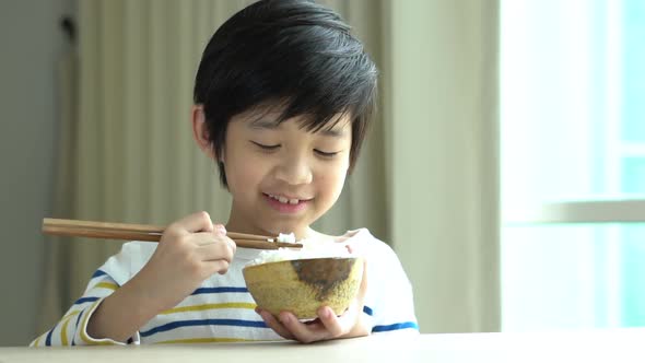 Cute Asian Boy Eating Rice With Chopsticks