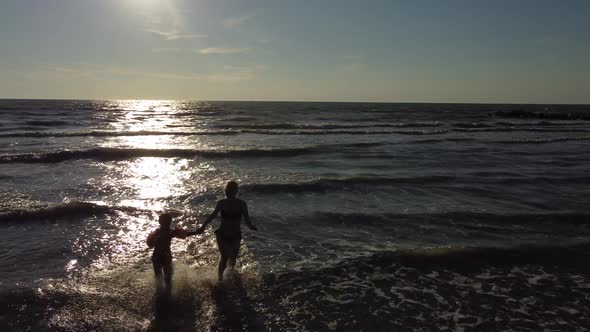 Mother and Daughter Playing on the Sandy Beach