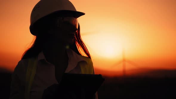 Silhouette Beautiful Caucasian Woman in White Helmet Working with Digital Tablet