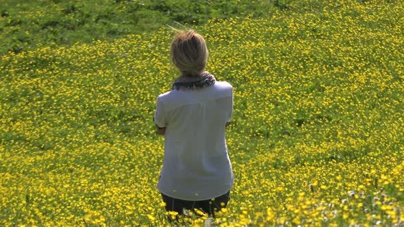 Blond Haired Alone Woman is Watching View in Yellow Flowery Meadow