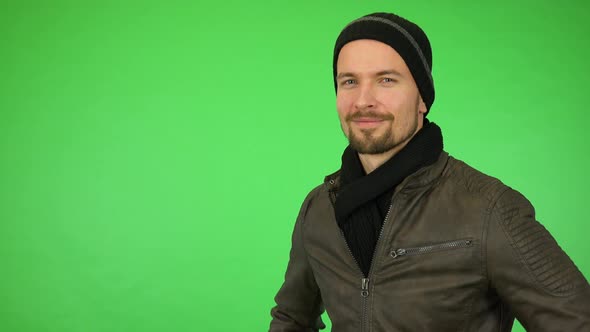 A Young Handsome Man in a Winter Outfit Smiles at the Camera - Green Screen Studio