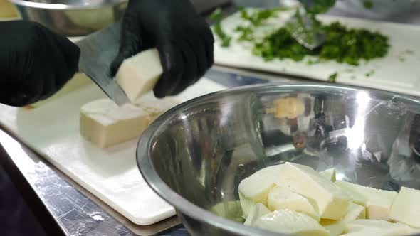 Chef Slicing Cheese Into Big Pieces