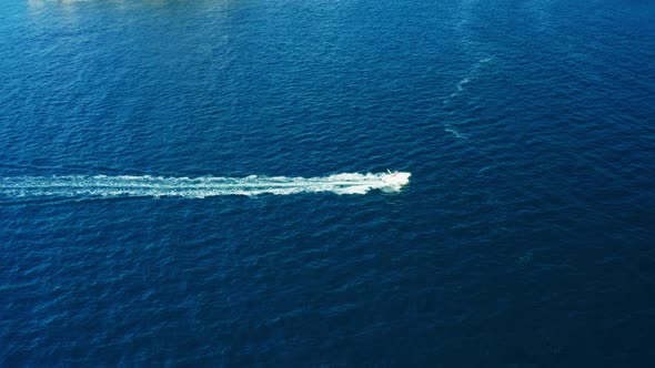 Motorboat Speeds in Sea Leaving Trail of Bubbles and Froth