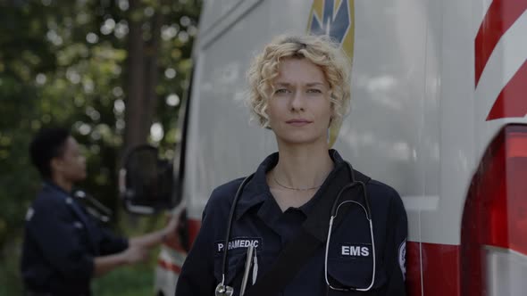 Outdoors Portrait of Female Paramedic Near Ambulance