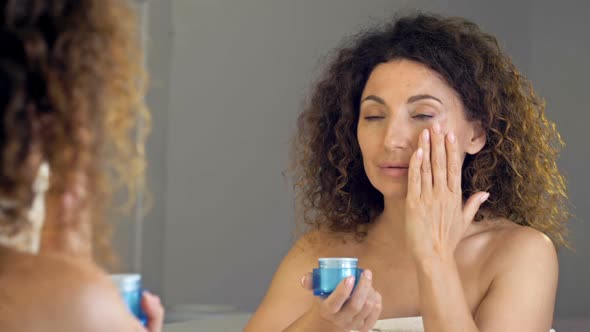 Beautiful Mature Woman Holding Jar of Skin Cream for Face