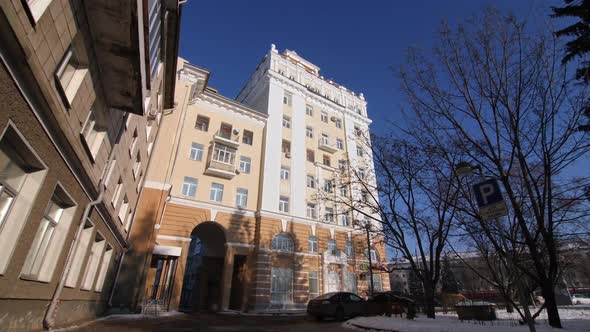 Classic Style Building with Arch Driveway on Snowy Street