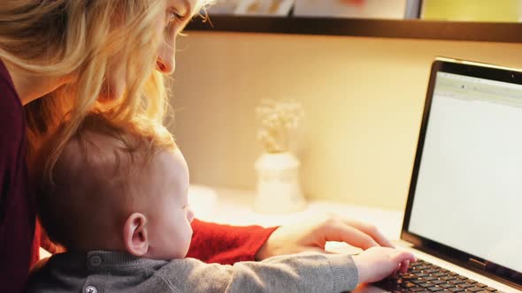 Mother and baby using laptop 4k