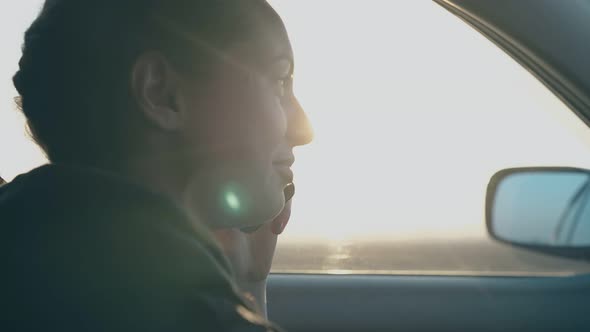 Joyful Girl Talks on Phone and Smiles Against Speeding Cars