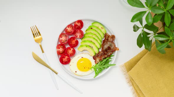 Healthy keto breakfast: egg, avocado, arugula, tomatoes and bacon. Stop Motion Animation