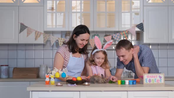 Family Feeding Cute Easter Bunny in the Kitchen