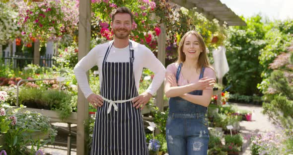 Outdoors Shot of Cheerful Male and Female Gardeners Looking at Camera