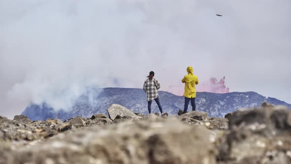 Adventurous Tourists Admiring the View of Volcano Eruption