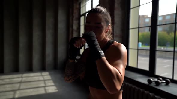 Young Boxer Woman Is Fighting with Camera, Striking and Training, Medium Portrait Shot in Movement