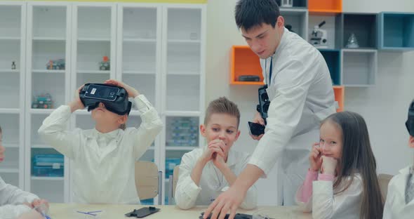 Little Children Teens in the Classroom Watching in Virtual Reality Glasses