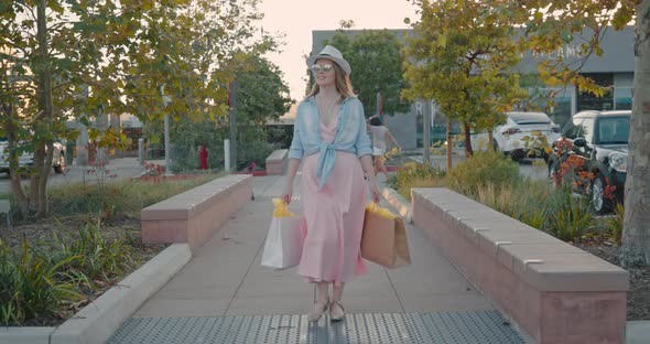 Woman with Shopping Bags Walking in Outdoor Shopping Mall After COVID-19, 