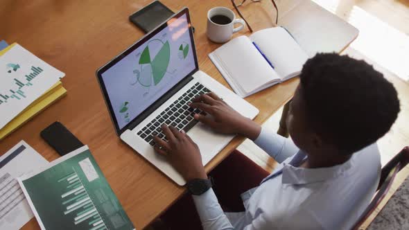 Overhead view of african american woman using laptop while working from home