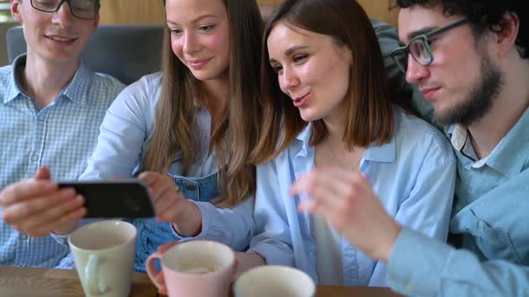 Young Friends Sit in a Cafe Drink Coffee and Have Fun Communicating