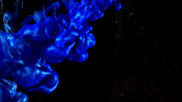 Deep blue shining glitter ink in water shooting with high speed camera. Art backgrounds. alt