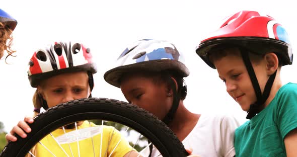 Group of kids looking at bicycle wheel