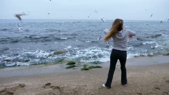 Mature Woman Is Doing Exercises On Sea Shore