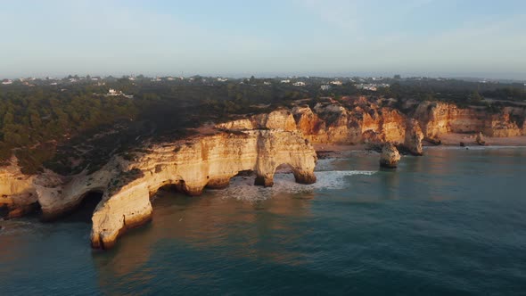 Aerial view of cliff with arch rock at Praia da Marinha at sunrise