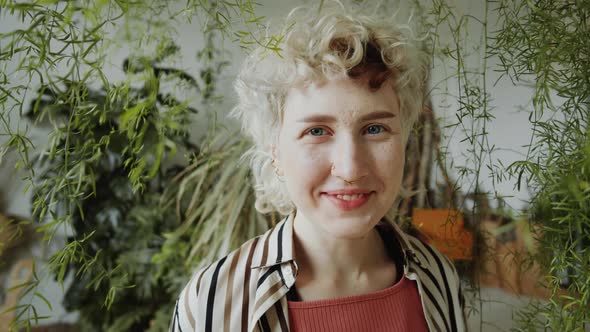 Portrait of Happy Girl in Flower Shop with Lots of Plants