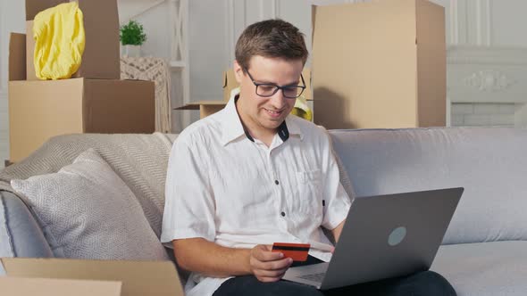 A Man Uses a Laptop For Online Shopping at Home