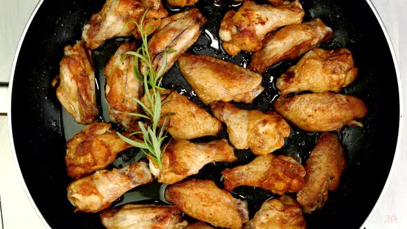 Many Sprinkled with Spices Sliced Chicken Wings Preparation and Turning in Hot Frying Pan