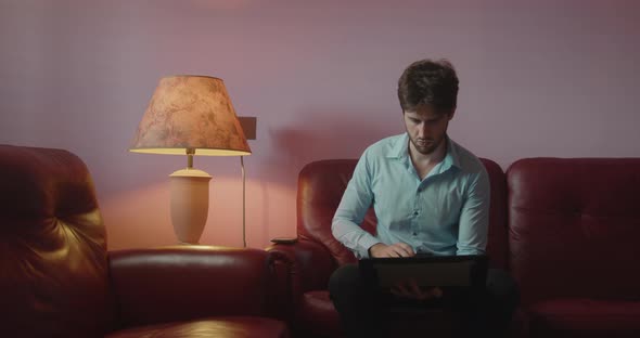 Businessman uses laptop sitting on the sofa