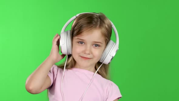 Baby Listens To Music Through the Headphones. Green Screen