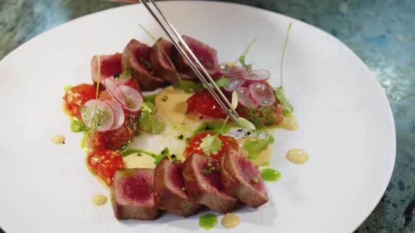 Elegant Woman Eating Tuna Steak with Colorful Salad in High Kitchen Restaurant Haute Cuisine Fine