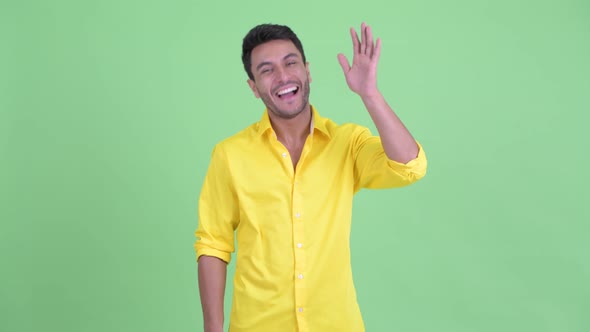 Happy Young Hispanic Businessman Waving Hand