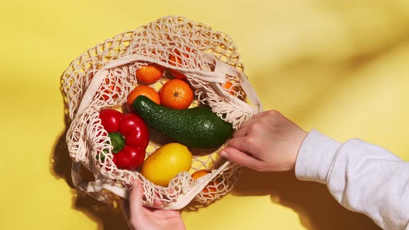 Organic fruits and vegetables in reusable and zero waste mesh cotton shopping bag.