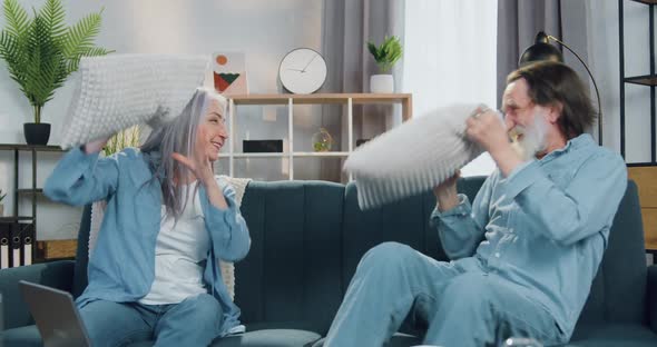 Mature Couple Having Fun while Playing with Pillows and then Hugging with Each Other