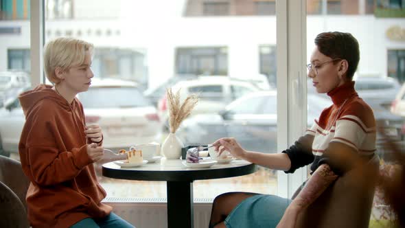 Young Girls Are Discussing the News in the Coffee Shop