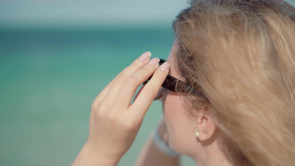 Girl Using Sunglasses On Vacation. Woman Wearing Sunglasses On Ocean Carribean Resort.