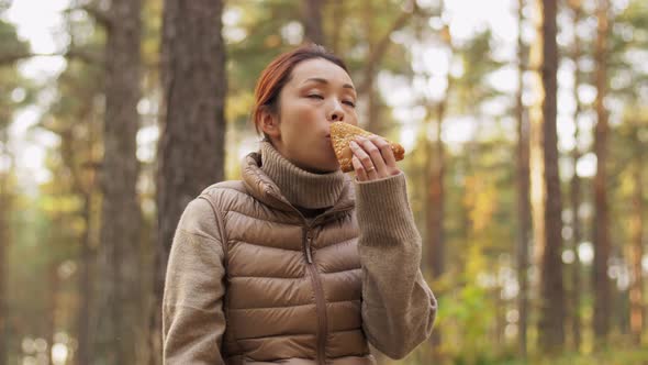 Woman Drinking Tea and Eating Sandwich in Forest