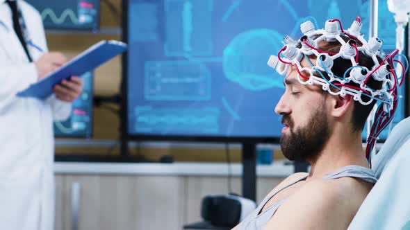 Patient with Brainwaves Scanning Headset Sitting on Bed