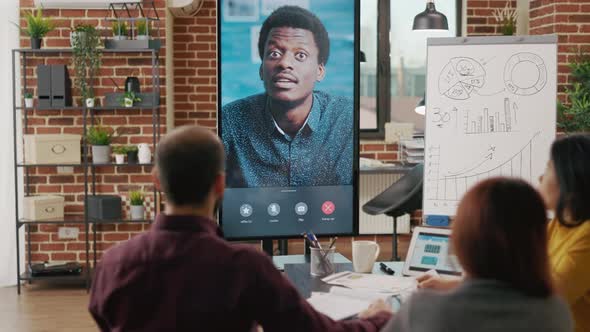 Colleagues Meeting with Man on Video Conference