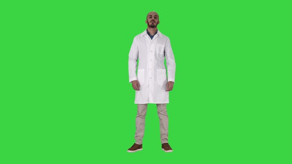 Doctor Man Is a Little Bit Nervous and Scared Standing on a Green Screen, Chroma Key.