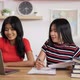 Portrait of Two Asian schoolgirl studying online on laptop and making notes in copybook - VideoHive Item for Sale