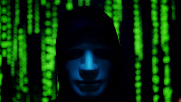 Close Up of a Anonymous Computer Hacker in Black Hood and Mask Over Abstract Binary Matrix