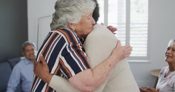 Caucasian senior woman giving support to african american female friend on meeting