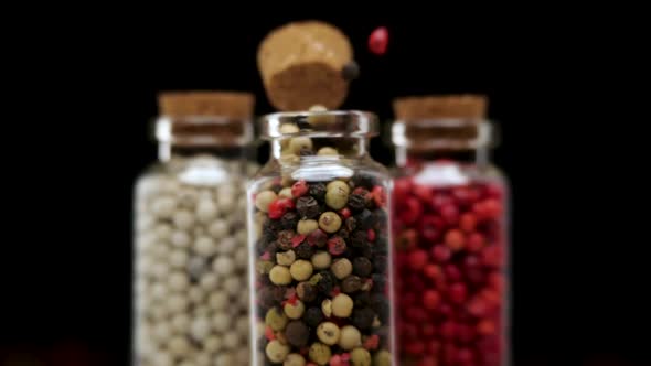 Mixed Peppercorns Flying Out of Glass Jar