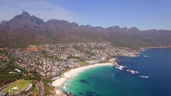 Aerial travel drone view of Camps Bay beach, Cape Town, South Africa.