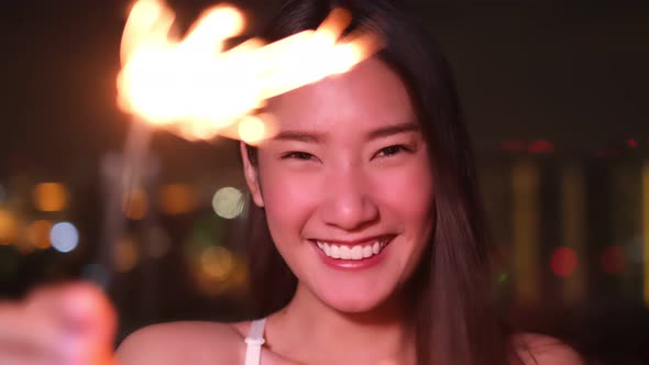 Young asian woman with sparklers is dancing and celebrating a new year. Fireworks,