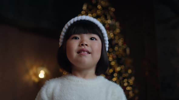 Korean Girl Child in a White Knitted Sweater and Hat Stands