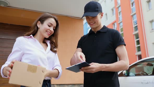 Delivery Service. Courier Delivering Box To Woman