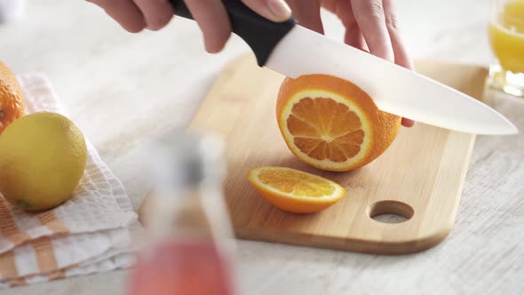 Preparing Ingredients For A Refreshing Summer Orange And Lemon Cocktail. Cutting  Orange Into Slices