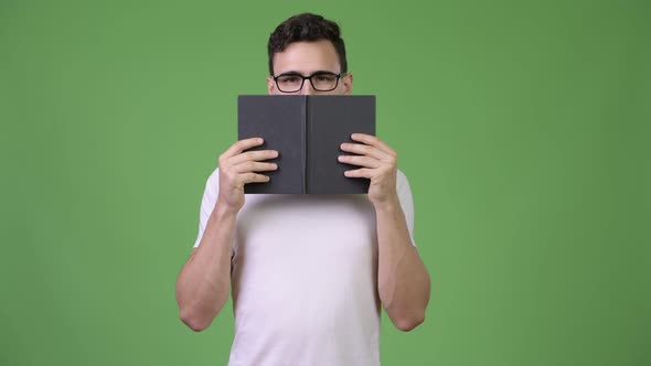 Young Handsome Nerd Man Covering Face with Book